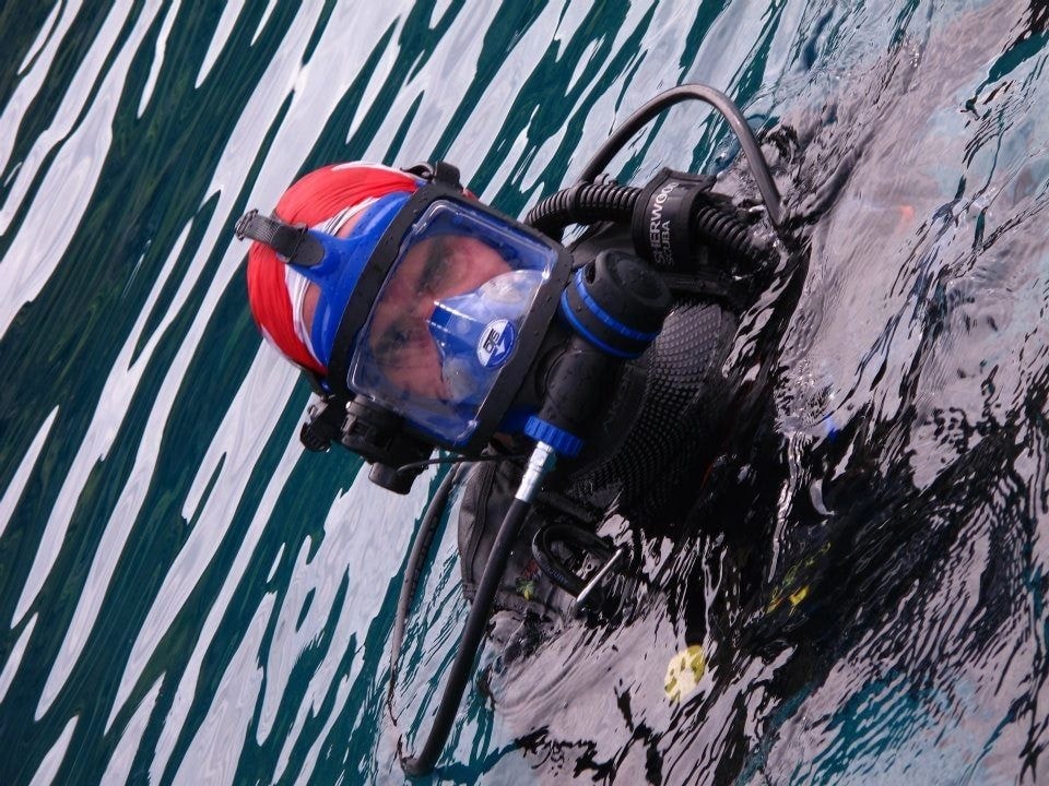 Buzo con casco rojo y azul en el agua